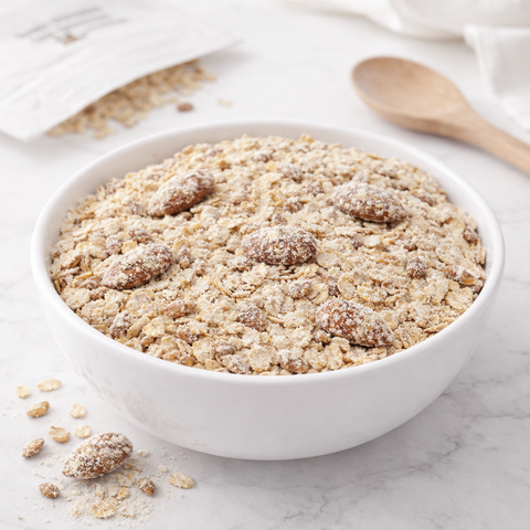 Bicchiere di latte di mandorla bio con mandorle pugliesi e colazione naturale su tavolo in legno