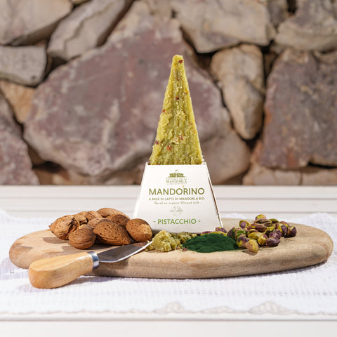 Mandorino al pistacchio vegetale affettato su tagliere con pane rustico e pistacchi