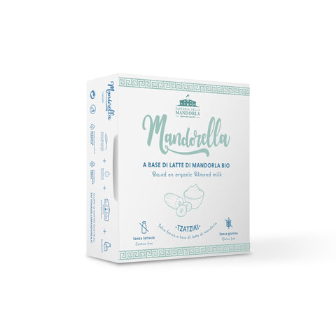 Piatto di pasta cremosa con mandorla, zucchine, basilico fresco e granella di mandorle su tavola luminosa