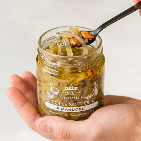 CIPOLLE SOTT'OLIO DI MANDORLA BIO - 310g — vasetto aperto in mano con cucchiaio